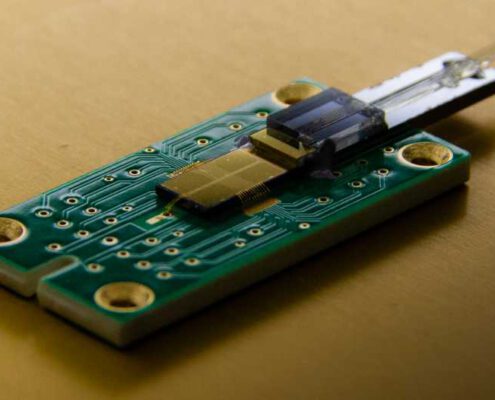 Integrated photonic ion trap chip in finished package with optical and electrical interface