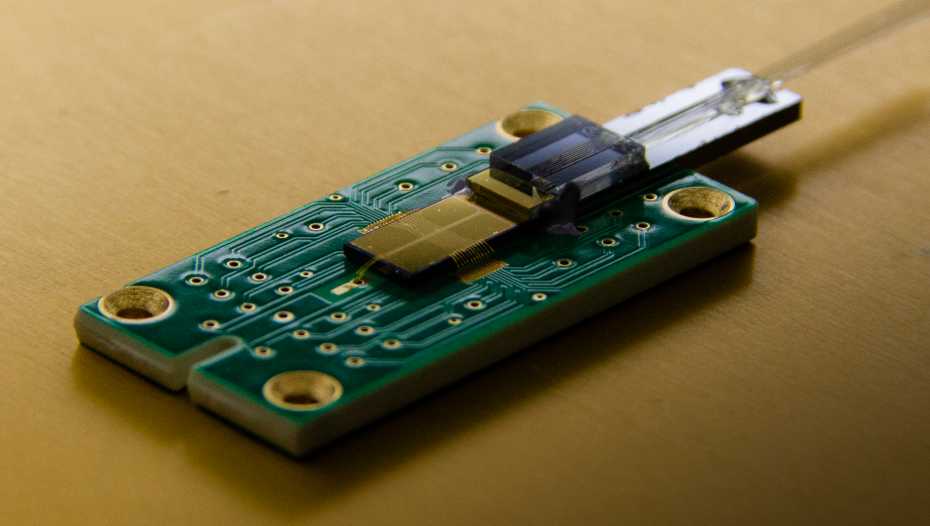Integrated photonic ion trap chip in finished package with optical and electrical interface