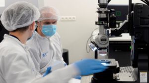 PhotonHub_press release two photonics engineers working in a clean room wearing protective equipment